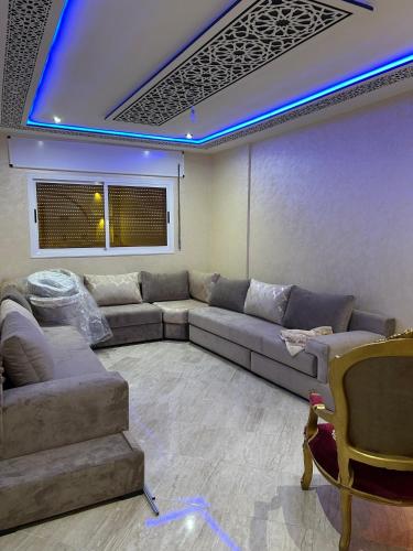 a living room with a couch and a blue light at appartement place mecca in Larache