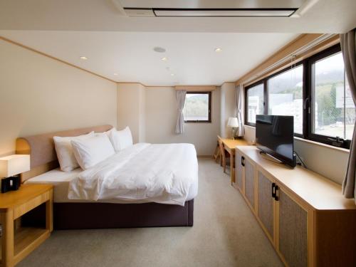a bedroom with a bed and a tv in it at T Hotel Ryuoo in Shimotakai