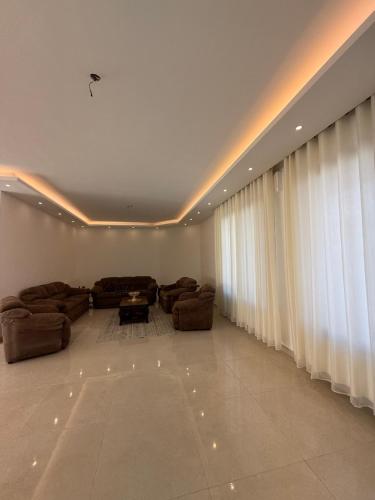 a living room with couches and a large window at Dabouq 3BR condo in Amman
