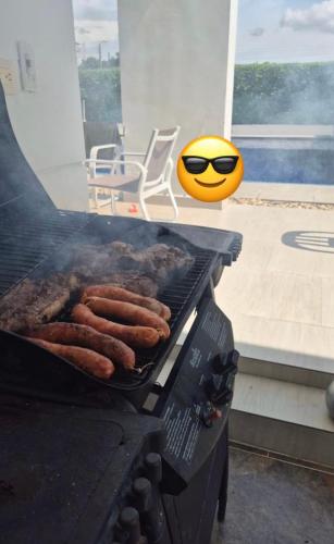 a bunch of sausages cooking on a grill at Casa Piscina Girardot Condominio Campestre in Flandes