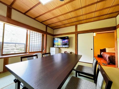 a dining room with a table and chairs and a bed at Yufuin Santoukan in Yufuin