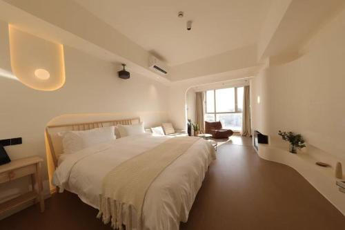 a white bedroom with a large bed and a window at Shanghai Hills & Wanda Side Spacious Stay Close to Metro Line 18 in Shanghai