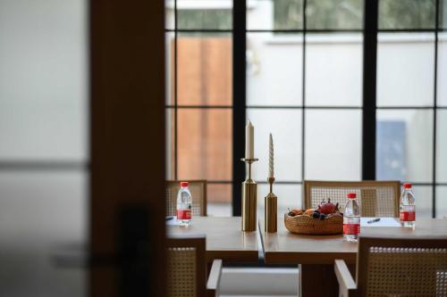a table with a bowl of fruit and bottles of soda at Dashuxia Hotel in Houhong