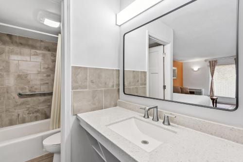 a bathroom with a sink and a mirror at Americas Best Value Inn & Suites Williamstown in Williamstown