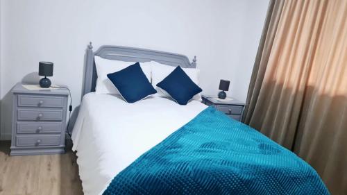 a bedroom with a bed with blue pillows at Casa Martins in São Vicente