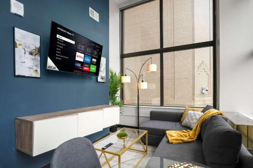 a living room with a couch and a tv at CozySuites At Presshouse in Pittsburgh