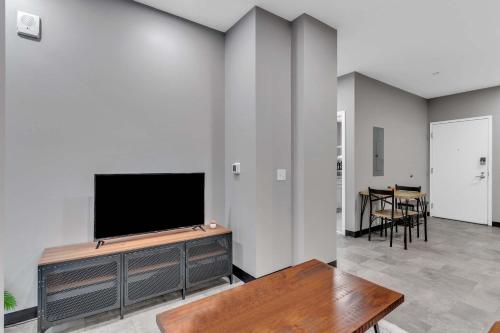 ピッツバーグにあるCozySuites Modern 1BR in Downtown Pitts #14の壁に薄型テレビが取り付けられたリビングルーム