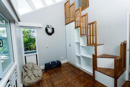 a staircase in a room with white walls and wooden floors at Luxury Hilltop Dual Villas With Stunning Sea Views & Pools ! in Lauwaki