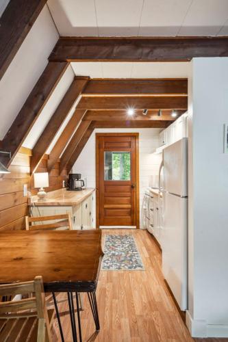 a kitchen with a wooden table and a refrigerator at Camp Conway Hot Tub AC New Kitchen Deck in Conway