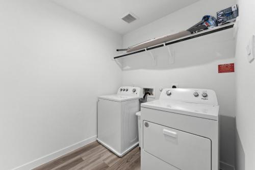 Un lavadero blanco con lavadora y secadora. en Cozy home away from home, en Houston