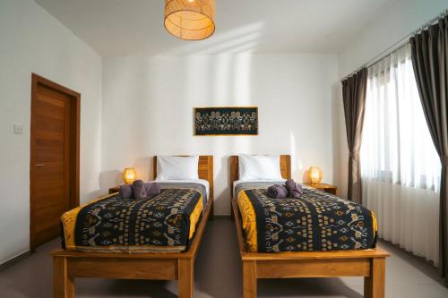 a bedroom with two beds and a window at Zena Surf Suite in Uluwatu