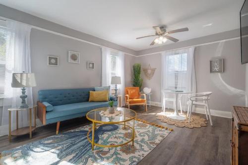 a living room with a blue couch and a table at Serene Beachy Bungalow with Large Screened Porch! in Tampa