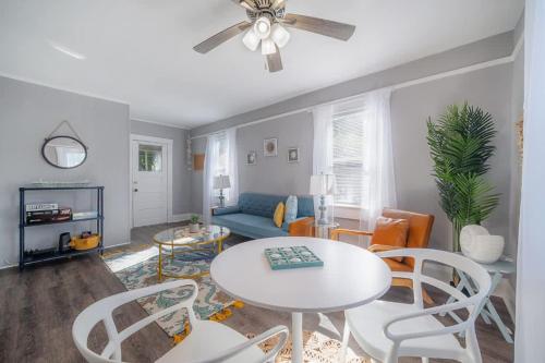 a living room with a couch and a table and chairs at Serene Beachy Bungalow with Large Screened Porch! in Tampa
