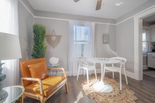 a living room with a table and a chair at Serene Beachy Bungalow with Large Screened Porch! in Tampa