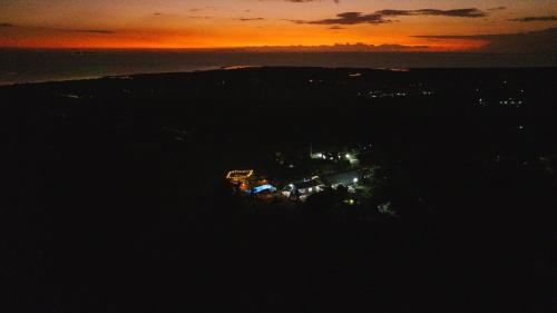 an island in the ocean with a sunset in the background at Luxury Hilltop Dual Villas With Stunning Sea Views & Pools ! in Lauwaki
