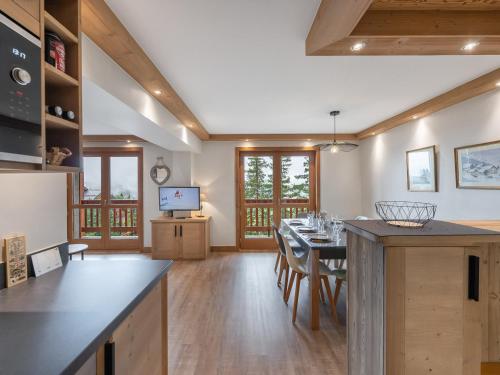 une cuisine et une salle à manger avec une table et des chaises dans l'établissement Méribel 6 pers - Appart 67m², 3 ch, Parking, WIFI - FR-1-565-121, à Les Allues