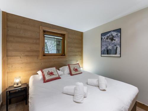 une chambre avec un grand lit blanc avec une fenêtre dans l'établissement Méribel 6 pers - Appart 67m², 3 ch, Parking, WIFI - FR-1-565-121, à Les Allues