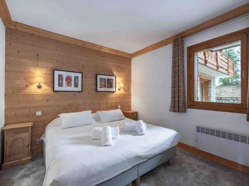 une chambre avec un grand lit blanc avec une fenêtre dans l'établissement Chalet Méribel 8 pers, ski-in/ski-out, 4 ch, WIFI - FR-1-565-117, à Les Allues