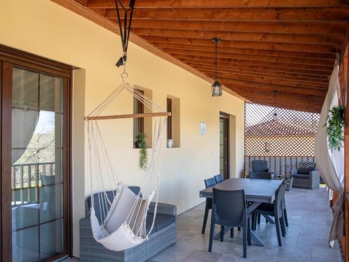 d'une terrasse avec une table, des chaises et un hamac. dans l'établissement Maison neuve à Sarlat avec jardin et terrasse - FR-1-616-488, à Sarlat-la-Canéda