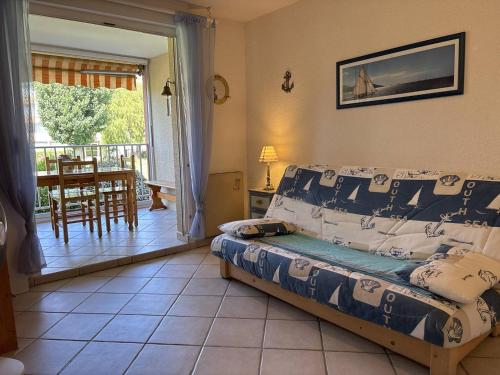 une chambre avec un lit et un balcon avec une table dans l'établissement Appartement 2 pièces cabine, proche plage, animaux acceptés - FR-1-826-16, à La Londe-les-Maures