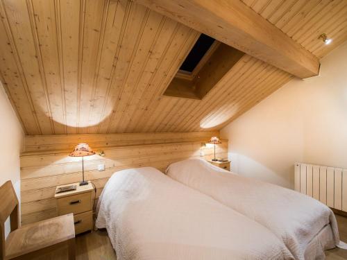 deux lits dans une chambre avec un plafond en bois dans l'établissement Duplex raffiné 3 chambres à Méribel, proche pistes - FR-1-565-120, à Les Allues