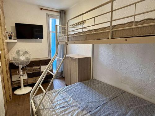 - une petite chambre avec des lits superposés et un ventilateur dans l'établissement Appartement T2 proche mer - Argeles-sur-Mer - FR-1-225-834, à Argelès-sur-Mer