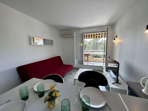 un salon avec une table et un canapé rouge dans l'établissement Appartement 2 pièces proche plage avec parking à Saint-Raphaël - FR-1-226A-209, à Saint-Raphaël