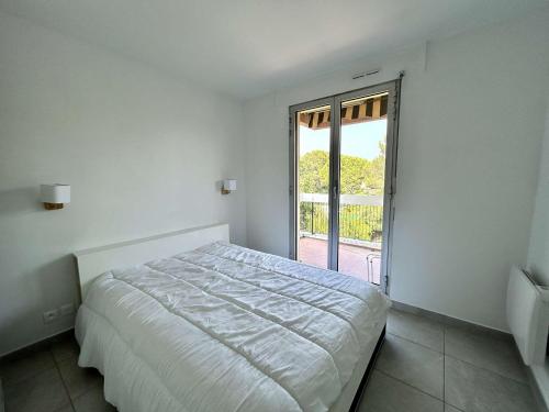une chambre blanche avec un lit et une grande fenêtre dans l'établissement Appartement 2 pièces proche plage avec parking à Saint-Raphaël - FR-1-226A-209, à Saint-Raphaël