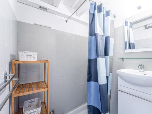 a bathroom with a blue and white shower curtain at Mimizan Plage Sud : Bel appartement pour 4, proche océan, parking privatif - Ménage inclus - FR-1-50-183 in Mimizan