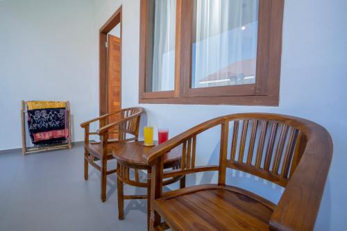 a dining room with a wooden table and two chairs at Zena Surf Suite in Uluwatu