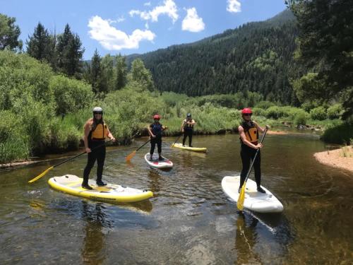 a group of people on paddle boards on a river at 2 BR 3BA Condo - AC, Heated Pool, Walk to Town in Aspen