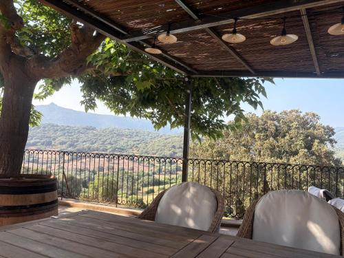 a table and chairs on a deck with a view at Entre mer et maquis- maison avec piscine privée - 8 minutes plage tizzano in Sartène