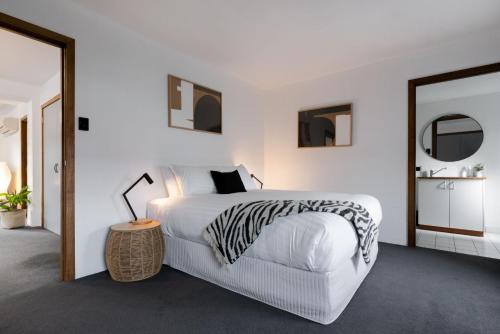 City Retreat with Parking في لونسيستون: غرفة نوم مع سرير ذو طبعة حمار وحشي ومرآة