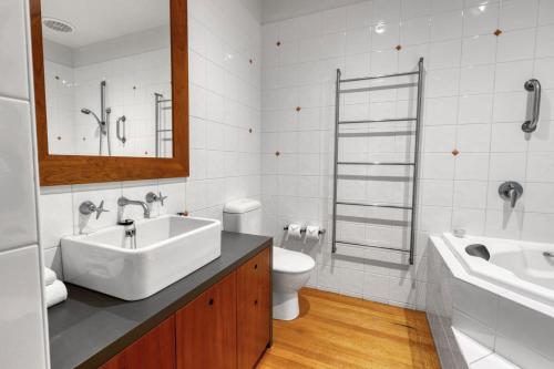 a bathroom with a sink and a toilet and a mirror at F&E Lakes Escape - East in Paynesville