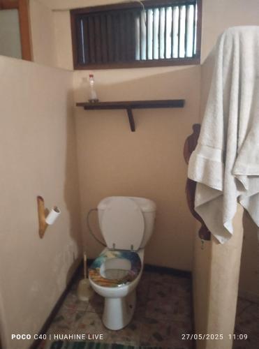 Un baño con un inodoro blanco en una habitación. en Chambre d'hôtes chez Vetea, en Fare
