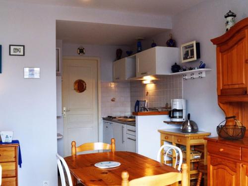 une cuisine avec une table en bois et un réfrigérateur blanc dans l'établissement Appartement RDC avec terrasse, à 200m de la plage des Générelles, parking et jardin privé - FR-1-22-229, à La Tranche-sur-Mer