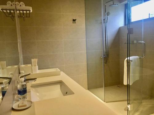 a bathroom with a shower and a sink and a toilet at SANCTUARY HỒ TRÀM RESORT - Near beach in Ho Tram