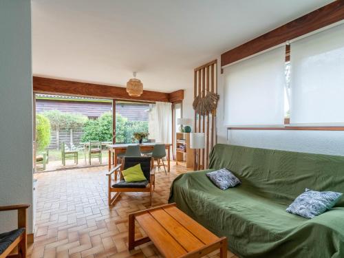 un salon avec un canapé vert et une table dans l'établissement Maison 3* à Mimizan Plage, proche Courant, 6 pers, 800m des plages, parkings, wifi, ménage inclus - FR-1-50-82, à Mimizan