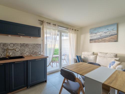 une cuisine et un salon avec une table et un canapé dans l'établissement Appartement moderne à Mimizan Plage, proche de l'océan, pour 6 pers, terrasse est - FR-1-50-159, à Mimizan