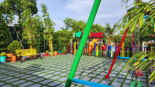 a playground with a colorful fence and a bench at Bell Farms and Resorts in Munroe Island