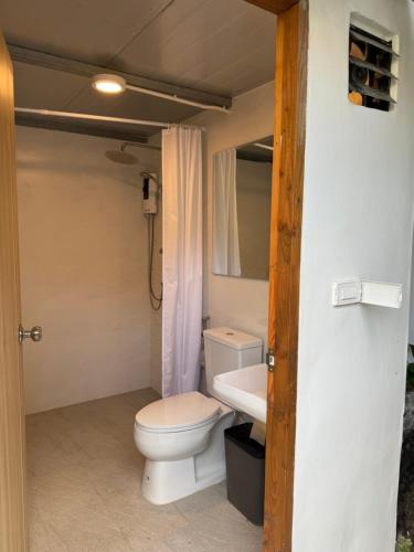 a bathroom with a toilet and a sink at Many Trees in Bangkok