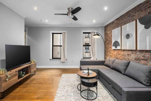 a living room with a couch and a tv at Modern Manhattan Retreat Near Central Park in New York