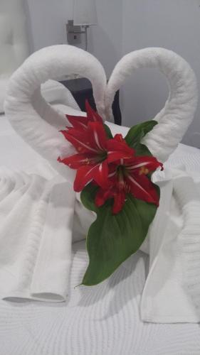 a red flower in a white bag on a bed at Hostal Boutique Bajamar in Nerja