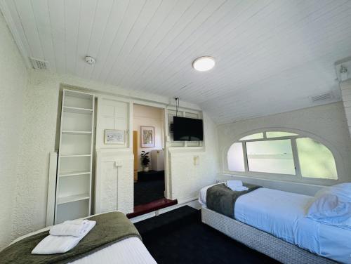 a bedroom with two beds and a window and a tv at 96B - Central Comfy Great Value - ST Kilda in Melbourne