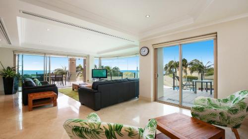 a living room with a couch and a tv at Unit 13 - 3 Bedroom Ocean View in Terrigal