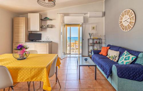 Una sala de estar con un sofá azul y una mesa. en Sunshine House, en Marina di Ragusa