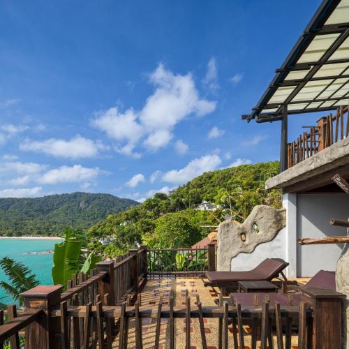 a balcony with chairs and a view of the water at Panviman Resort Koh Phangan in Thong Nai Pan Noi