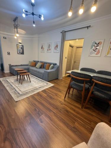 a living room with a couch and a table at 1st Luxury and Hotel apartments super stylish AbourCity in El-Sa`âida
