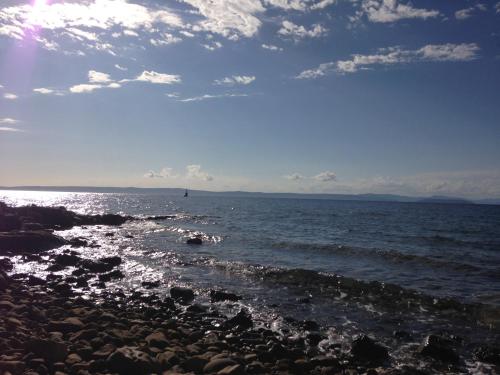 a beach with rocks and the ocean on a cloudy day at Guesthouse Tariba in Supetarska Draga
