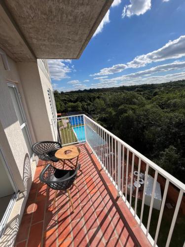 a deck with a table and chairs on a balcony at Departamento amoblado en Luque in Luque